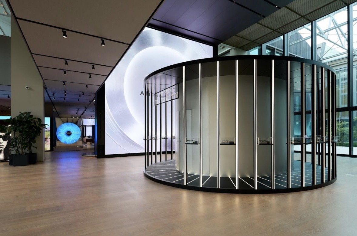 A visitor moving a glowing sphere across a curved console while instructions are projected on the wall behind